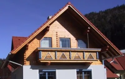 Giebel in Blockbauweise mit verziertem Holzbalkon