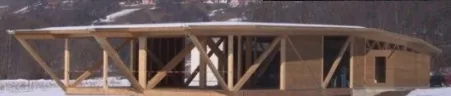 Werkhalle mit sichtbarem Holzfachwerk im Schnee