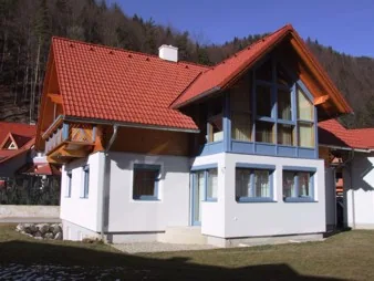 Wohnhaus mit Holzgiebel und blauen Fenstern